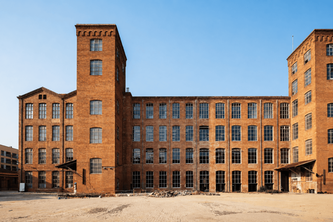 Façana interior del recinte de Fabra i Coats, amb edificis industrials de maó i grans finestrals