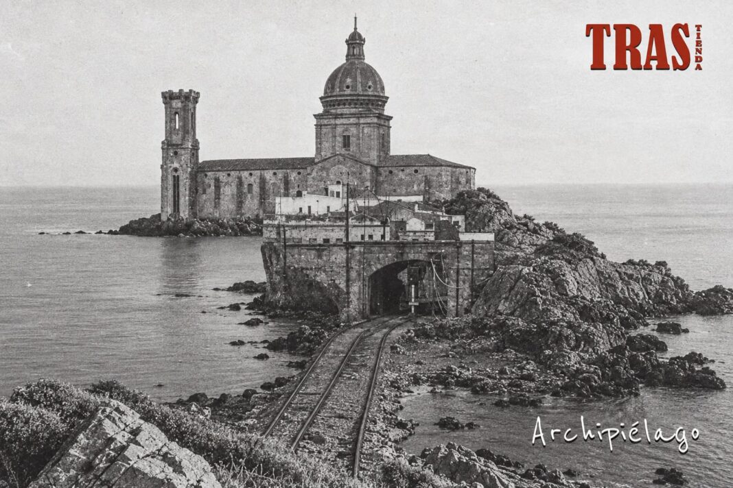 Portada d’Archipiélago de Trastienda, en blanc i negre, amb un edifici vora el mar i unes vies en primer terme.